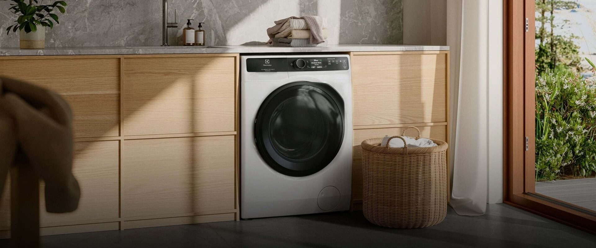 Edestä täytettävä pesukone kodinhoitohuoneessa.